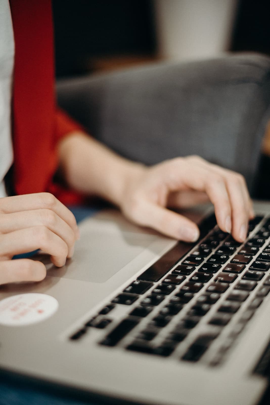 Hands typing on a laptop while comparing software options