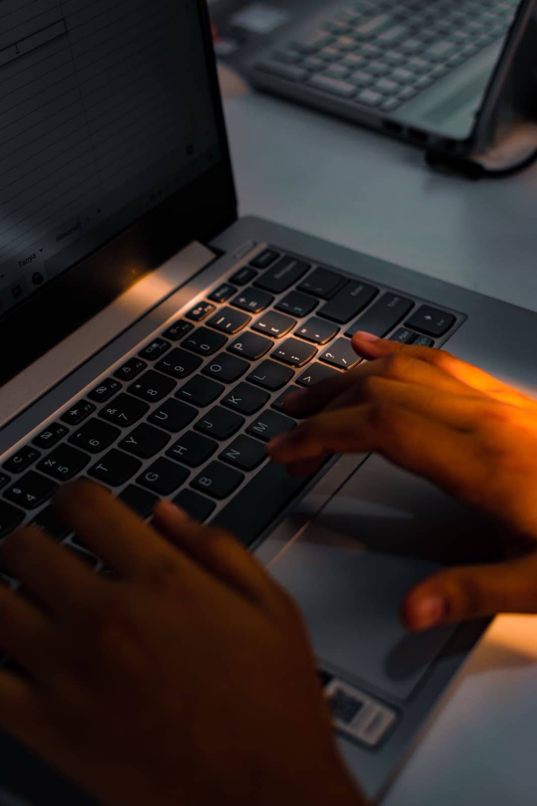 Close-up of hands typing on a laptop keyboard