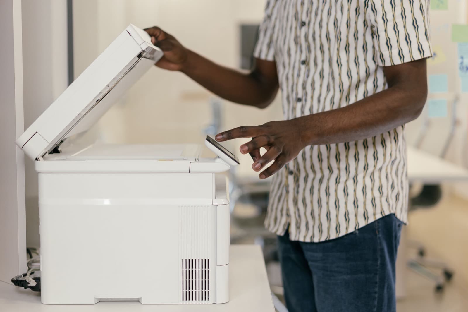 A person scanning a paper document on a photocopier
