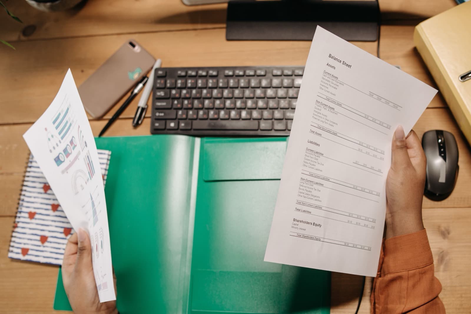 Hands holding and reviewing a printed financial statement
