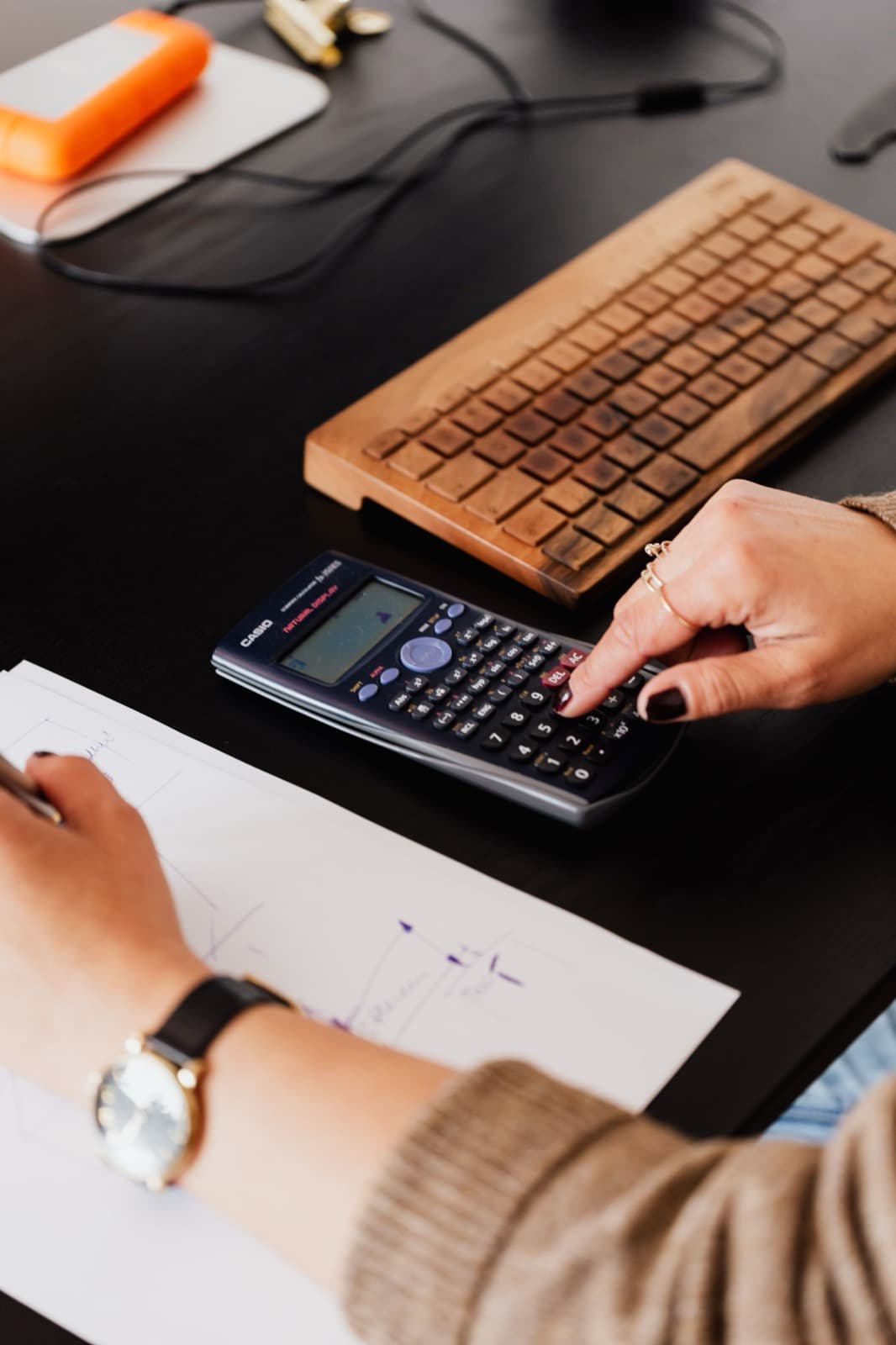 A bookkeeper reviewing documents alongside a calculator and keyboard