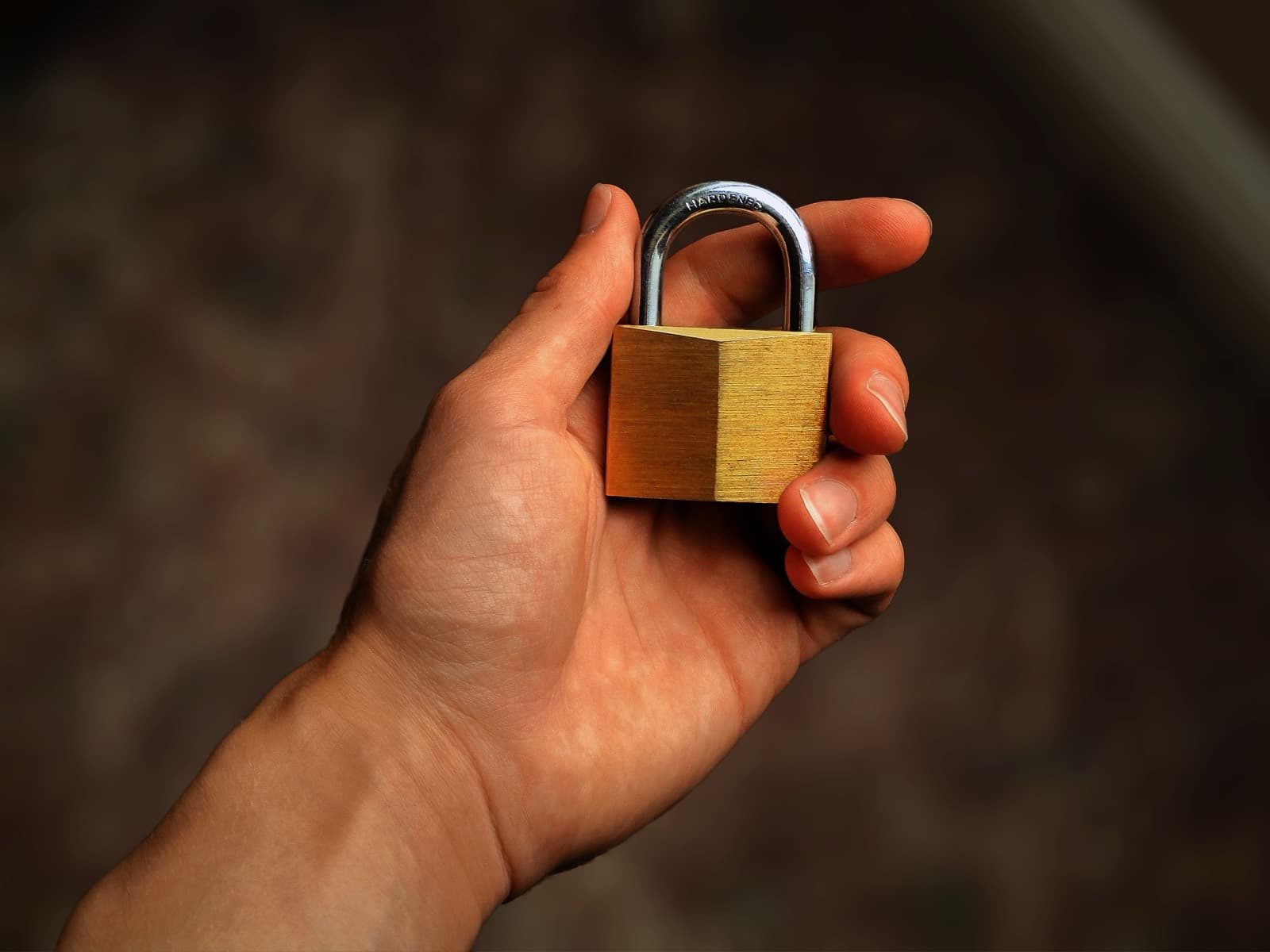 A hand holding a padlock, symbolizing data security