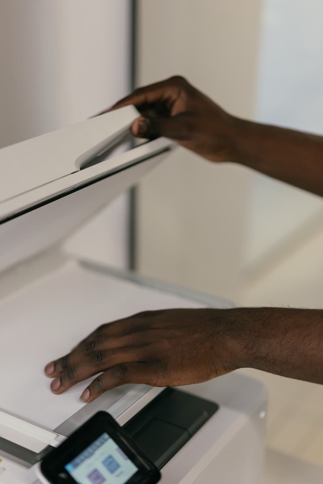 A person feeding a paper document into a scanning machine